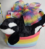 Kids rainbow gift basket with large plush orca, coloring books, candy, topped with handmade rainbow bow and mylar ballons.